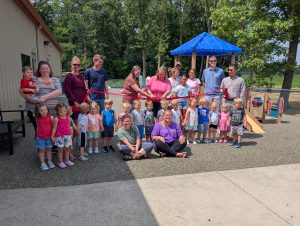 A ribbon cutting marked the dedication of a new rubberized surface at the Wee Care Learning Center's playground. (Sam Shriver/CherryRoad Media)
