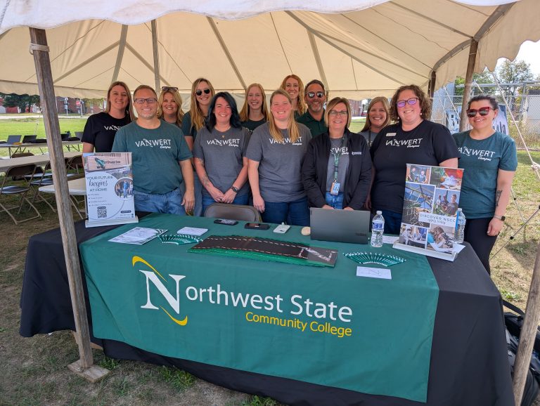 Northwest State Community College personnel gather under a tent at the Van Wert Campus for student visitation day. (Sam Shriver/CherryRoad Media)